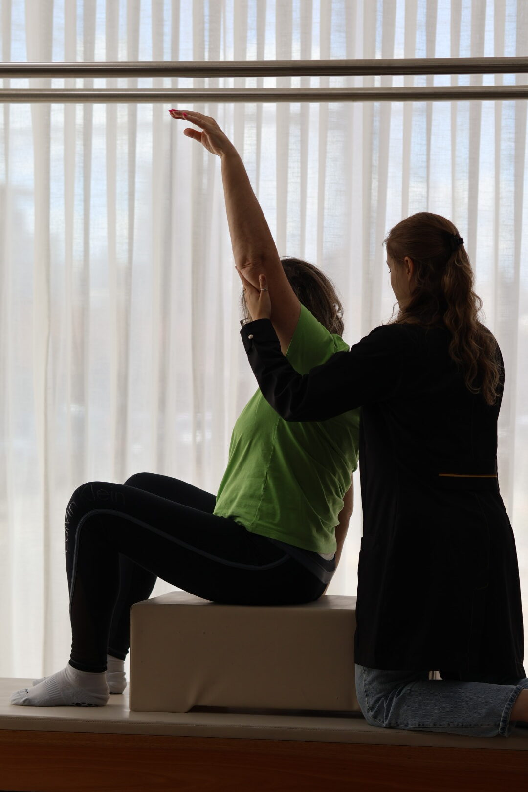 Fisioterapeuta auxiliando paciente com hérnia de disco em exercício de fortalecimento